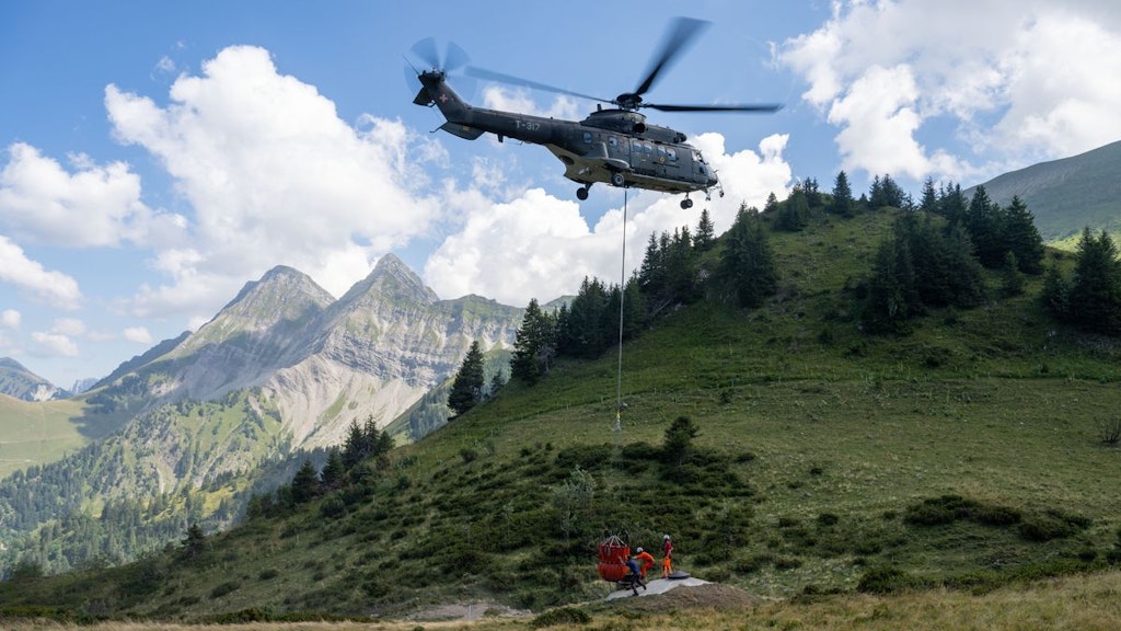 A Super Puma TH06 helicopter transporting water 