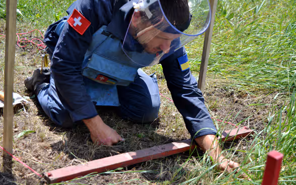 Un expert désamorce une mine en Ukraine, afin de réduire le danger auquel est exposée la population.